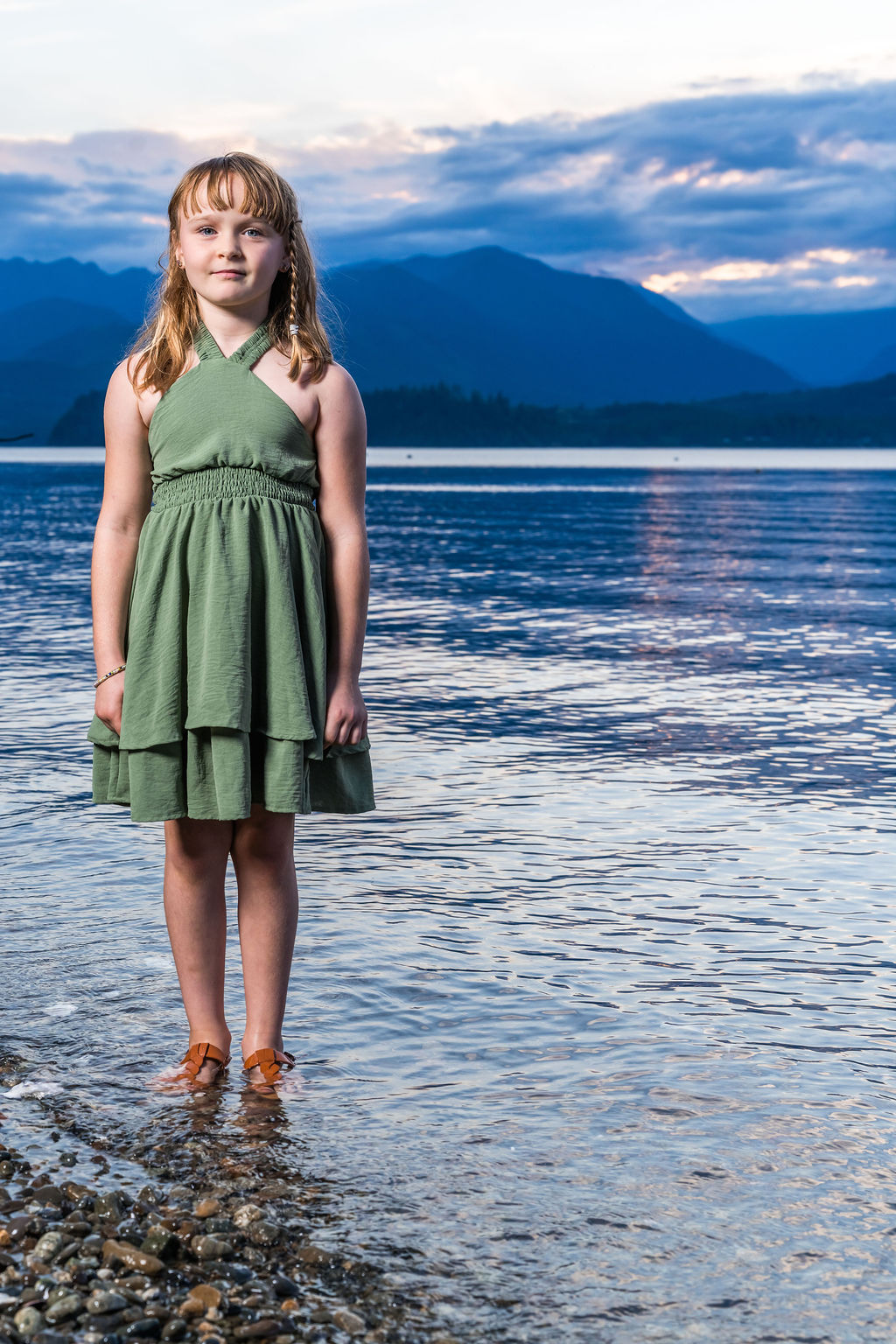 Young girl at the water's edge at sunset during a family beach photo session in Washington