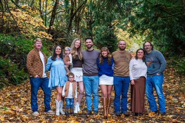 Large extended family on a leaf covered path during a fall family photo session in Washington