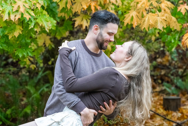 Couple sharing a tender moment among golden autumn leaves