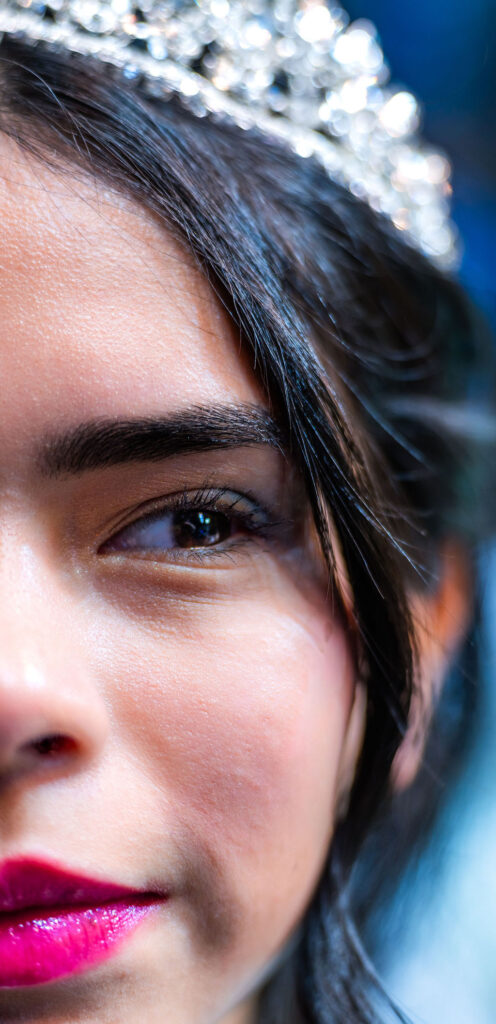 Close-up quinceañera portrait showing tiara, eye, and makeup detail