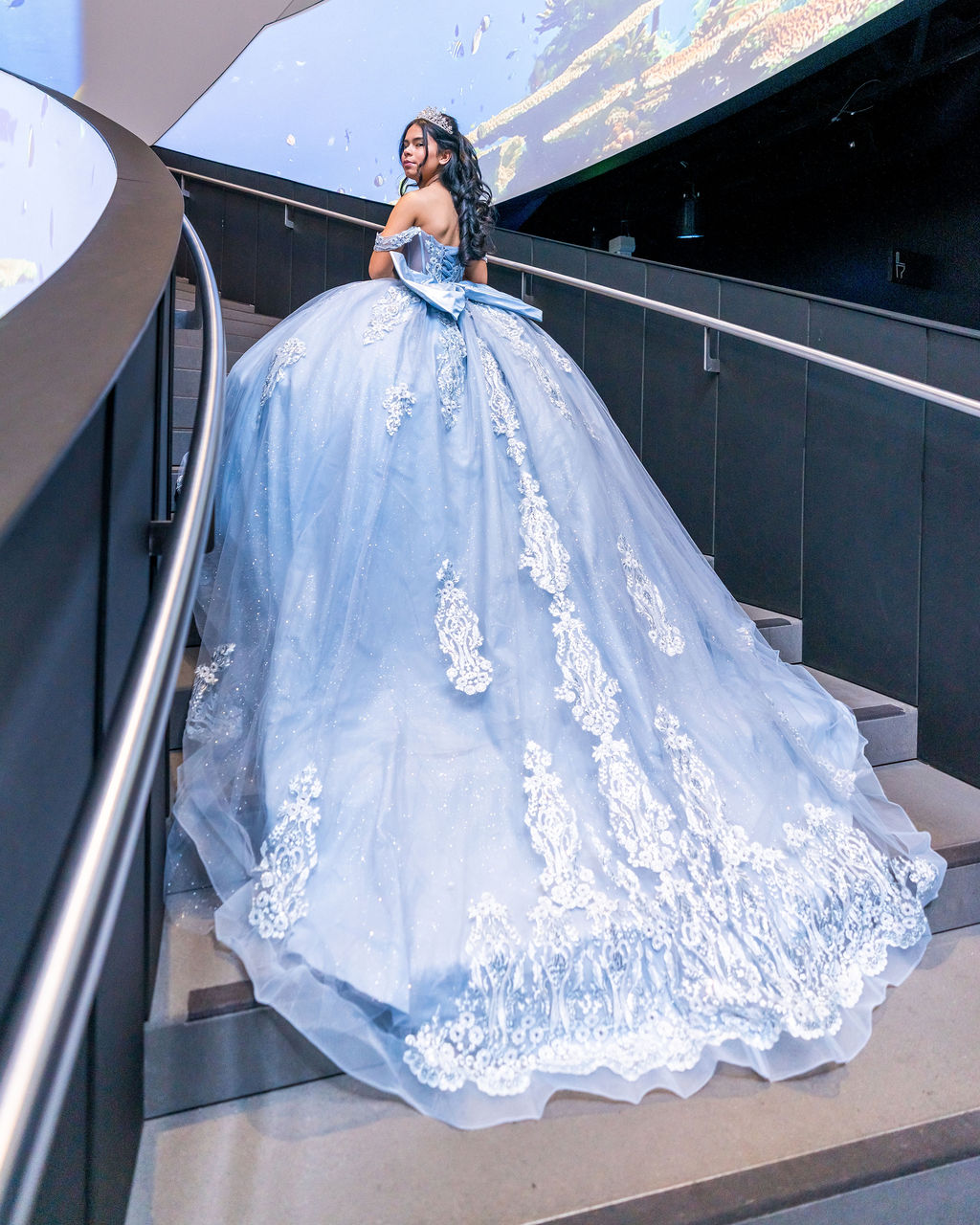Quinceañera portrait in blue ball gown on staircase at Seattle Aquarium