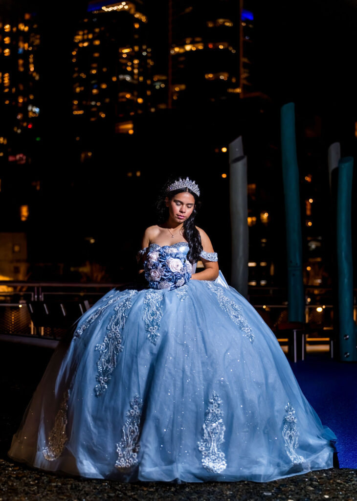 Quinceañera portrait in blue dress with city lights in Bremerton Washington