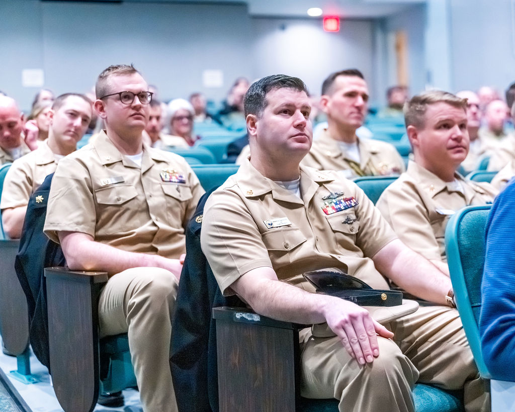 Chief petty Officers and Officers in seats during retirement ceremony.