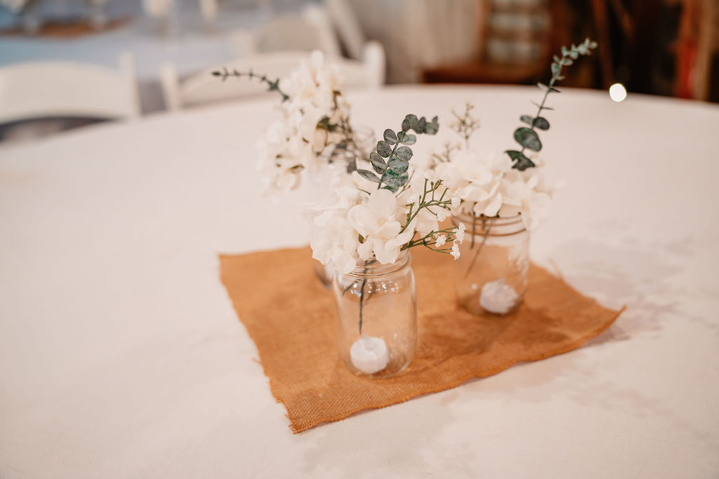 Rustic wedding centerpiece with flowers in mason jars at Burley Creek Nursery wedding venue in Port Orchard Washington