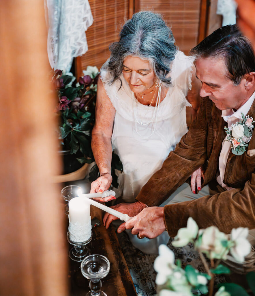 Bride and groom lighting a unity candle during their wedding ceremony at Burley Creek Nursery rustic wedding venue in Kitsap County Washington