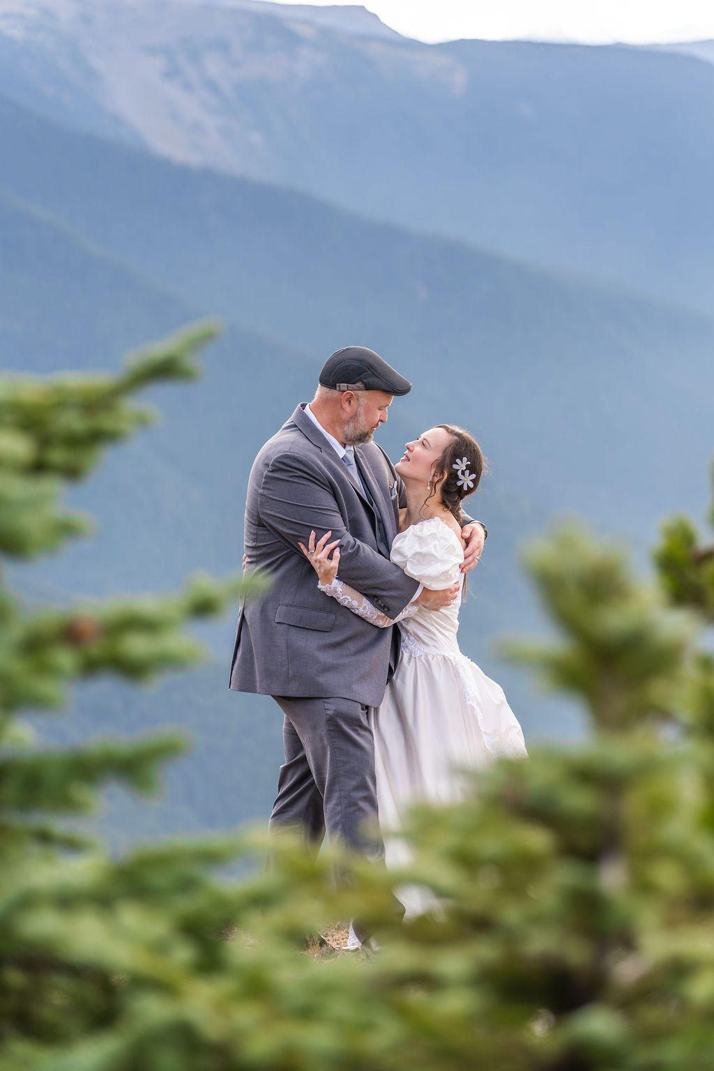 Wedding portrait of a couple framed by evergreens on a ridge in the Olympic Mountains Washington