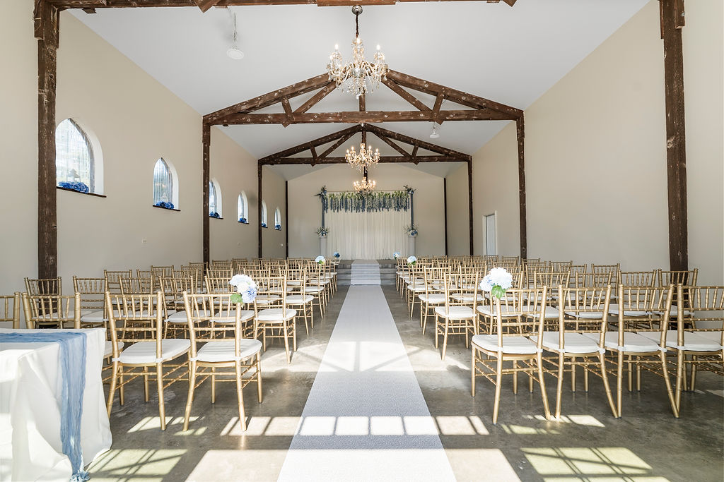 : Indoor chapel ceremony space with wooden beams and chandeliers at Vickery Gardens Tacoma wedding venue