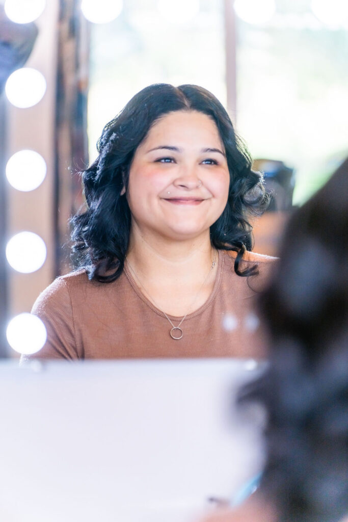 Bride smiling during wedding day makeup preparation before ceremony at Vickery Gardens