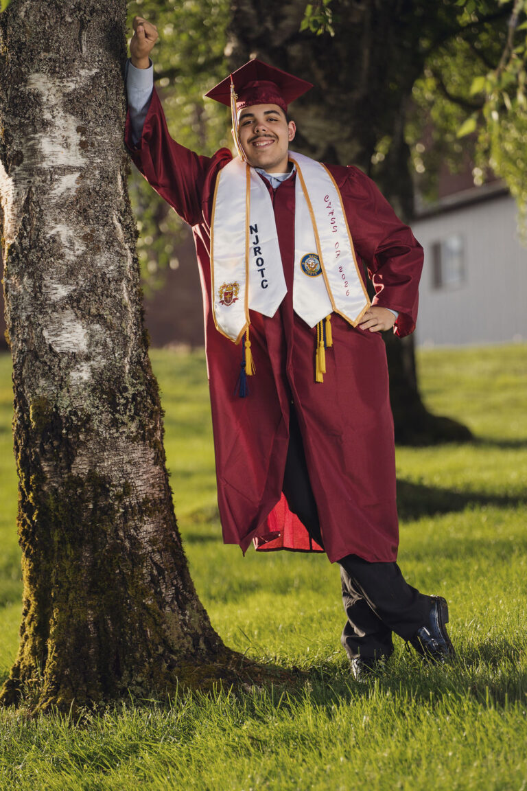 High school graduate in a maroon cap and gown at a Kitsap County senior session