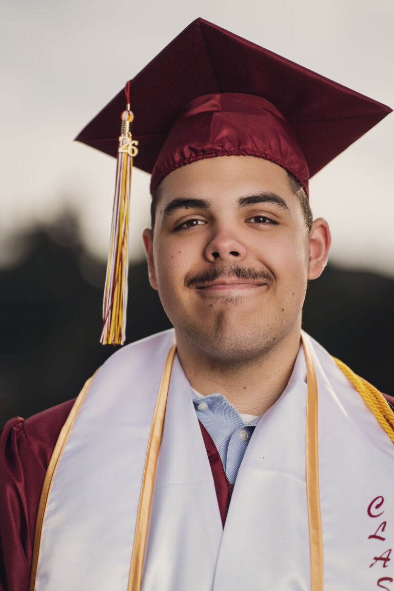 Close up graduation portrait of a high school senior in a maroon cap and gown in Kitsap County. Cap and gown photos Kitsap County.