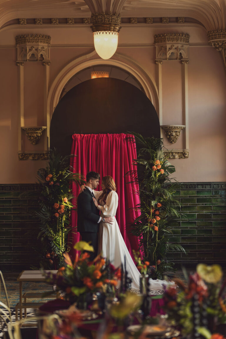Bride and groom embracing indoors in an ornate historic ballroom, a beautiful rainy day backup location