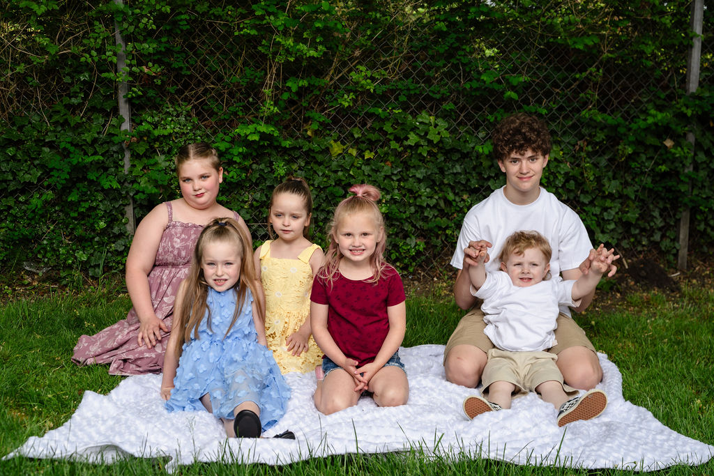 Group of children sitting together on a blanket at a Kitsap County park