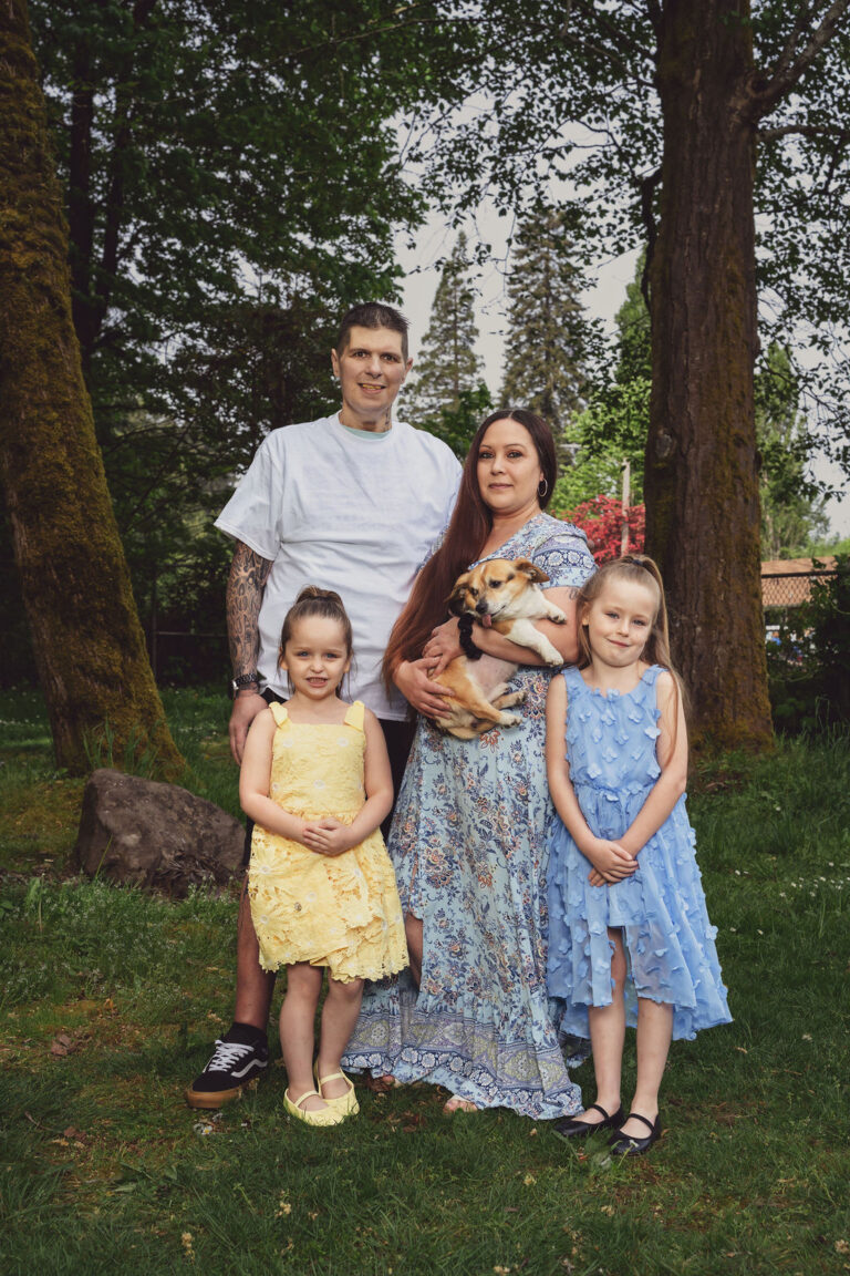 Family of four holding their small dog during a relaxed Kitsap County family photo session