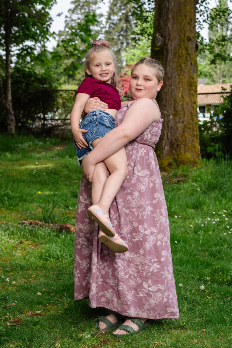 Older sister holding her little sister during an extended family session at a Kitsap County park
