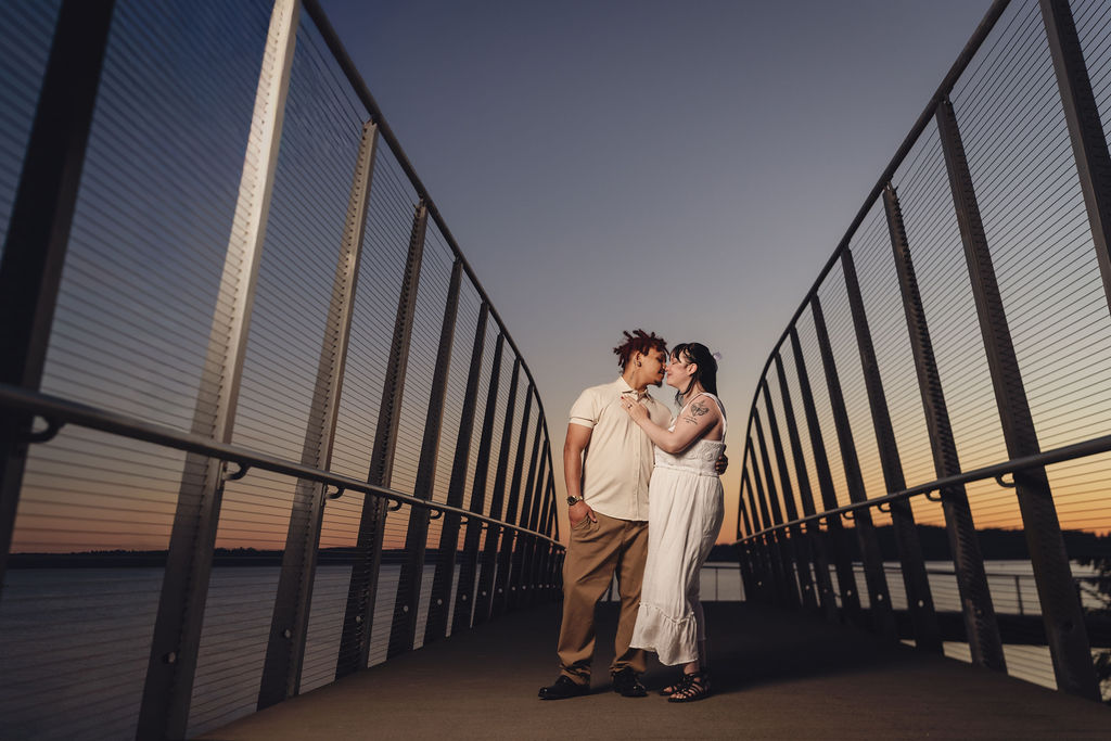 Engaged couple about to kiss on the boardwalk pier at Chambers Bay at sunset near Tacoma
