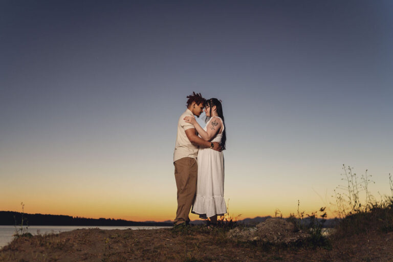Engaged couple forehead to forehead on a bluff, a moody winter engagement location near Kitsap