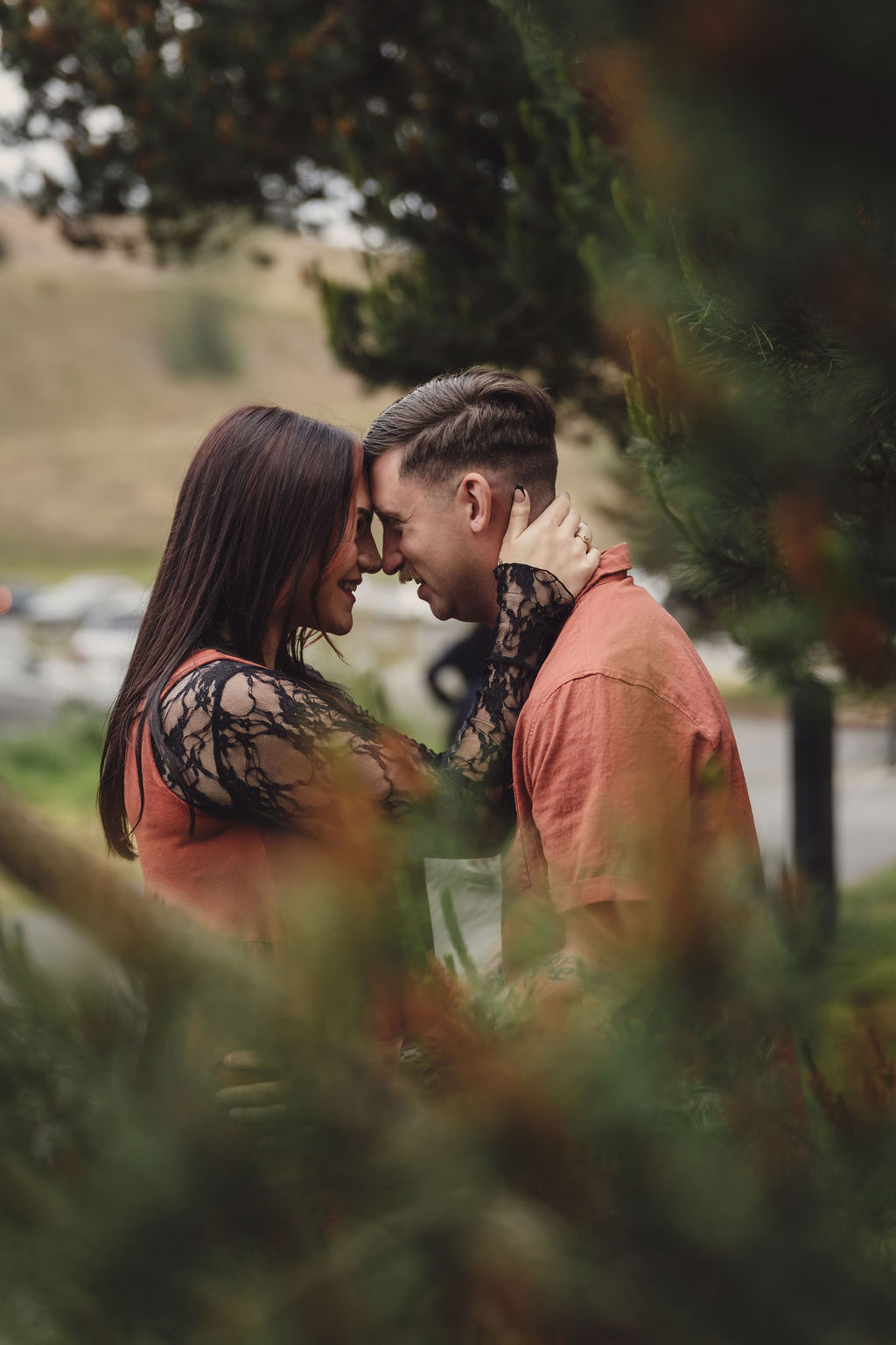 Engaged couple forehead to forehead with the bride to be's engagement ring showing at Chambers Bay near Tacoma