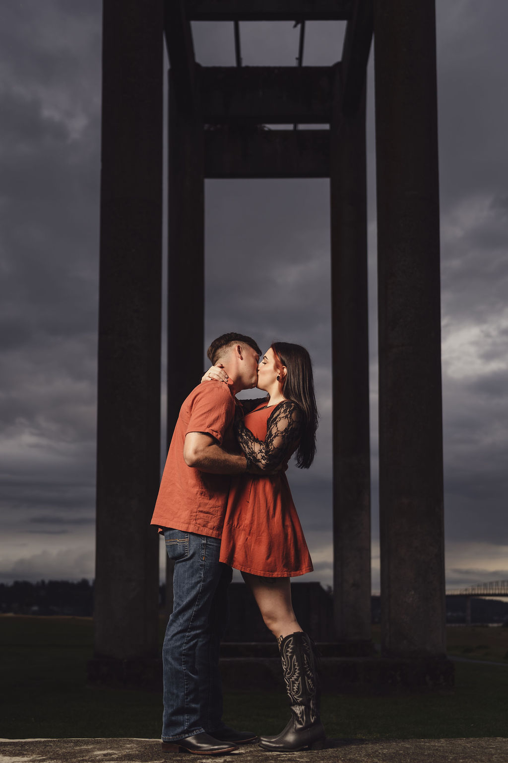 Engaged couple kissing beneath the concrete ruins at Chambers Bay near Tacoma at dusk, the kind of photo worth printing