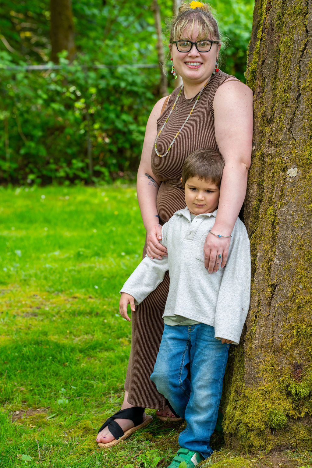 Mother and her young son leaning against a mossy tree during a Kitsap County park session