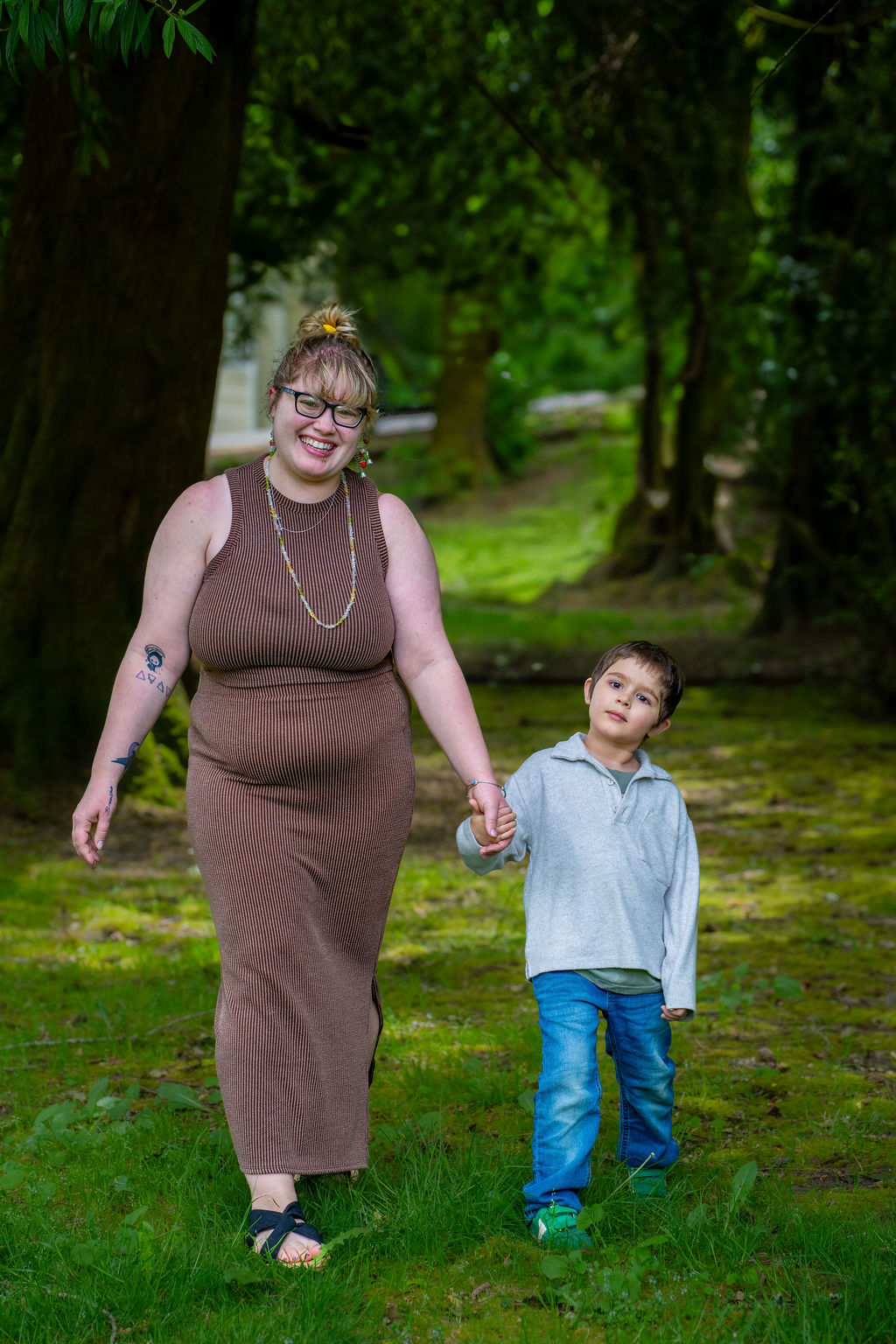 Mother and son walking down a tree lined path at a Kitsap County park