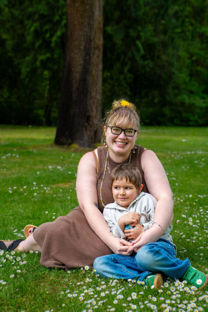 Mother and her son smiling together in a grassy park meadow in Kitsap County