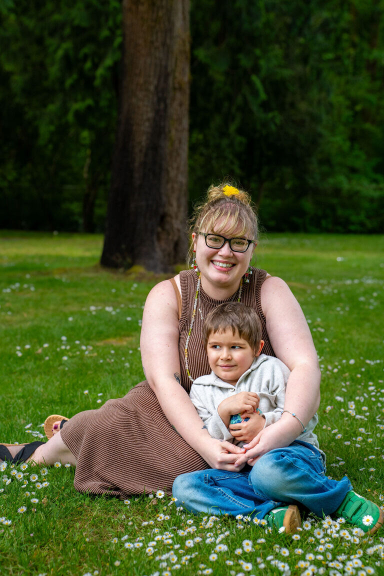 Mother and her son smiling together in a grassy park meadow in Kitsap County