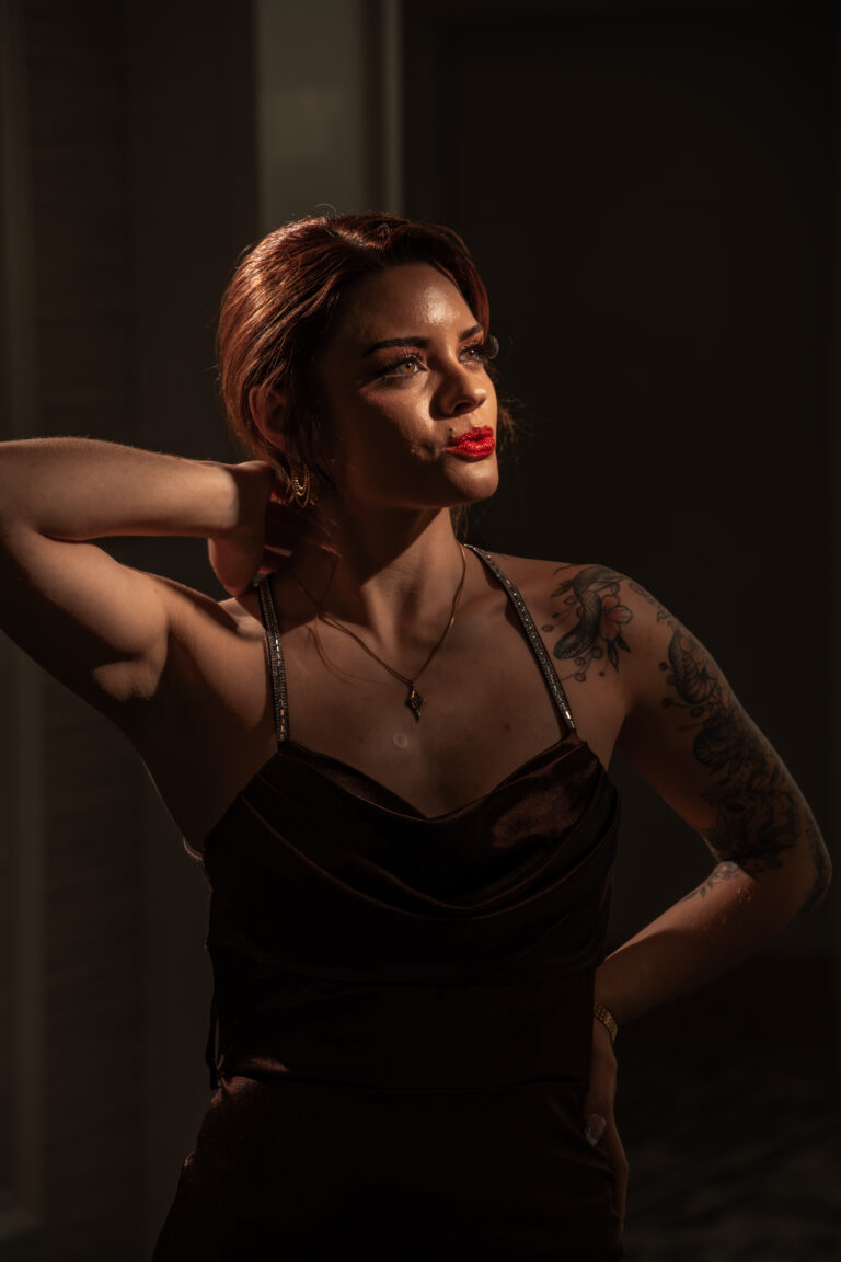High fashion senior portrait with polished glam hair and makeup in dramatic light