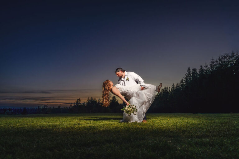 Bride and groom in a creative sunset dip portrait at the Mason Jar Gathering Barn, off camera flash wedding photography