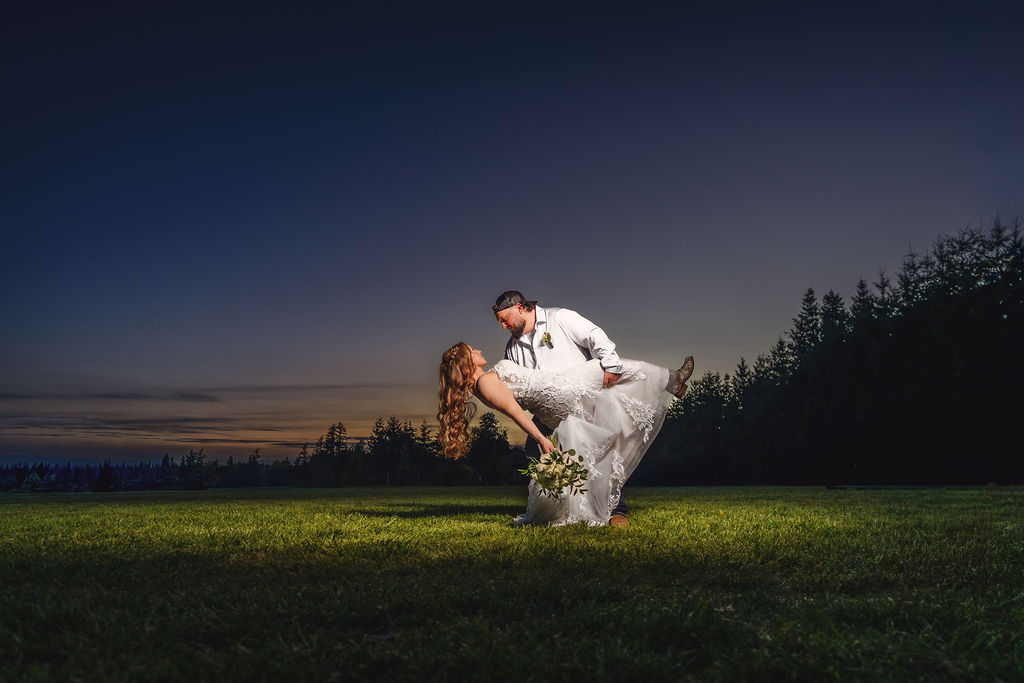 Bride and groom in a creative sunset dip portrait at the Mason Jar Gathering Barn, off camera flash wedding photography