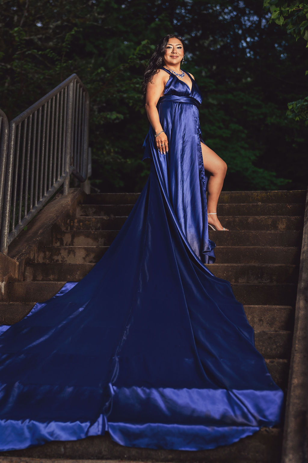 Woman in a royal blue gown with a dramatic train spilling down stone steps at Scenic Beach State Park near Seabeck