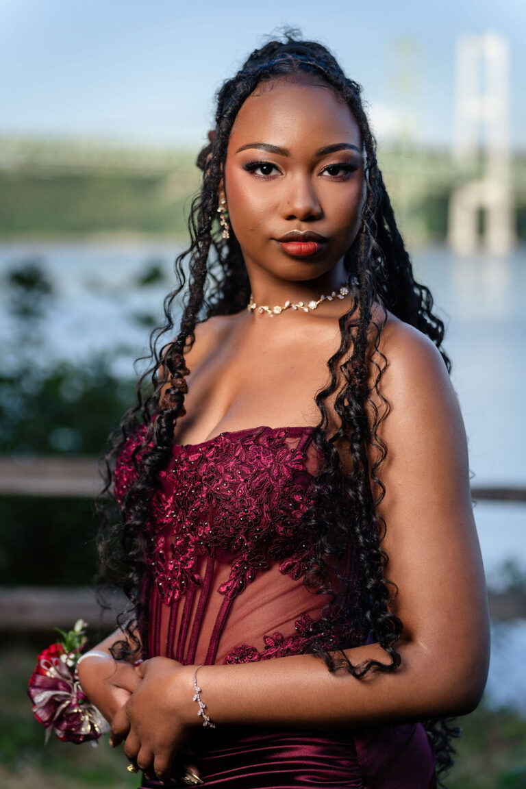 South Kitsap High School senior in a burgundy lace prom dress with a wrist corsage at the Tacoma Narrows Bridge viewpoint
