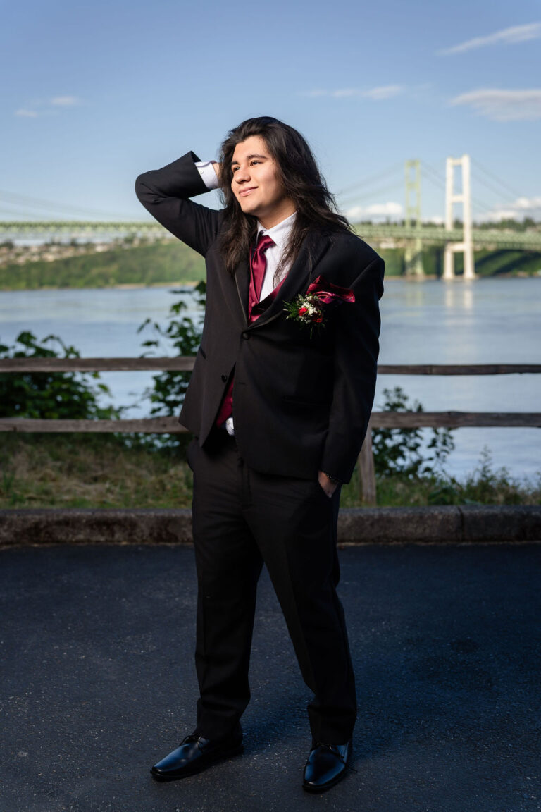South Kitsap prom senior in a black suit with a burgundy vest and tie at the Tacoma Narrows Bridge viewpoint