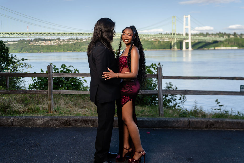 South Kitsap prom couple posing with the Tacoma Narrows Bridge and water behind them at golden hour