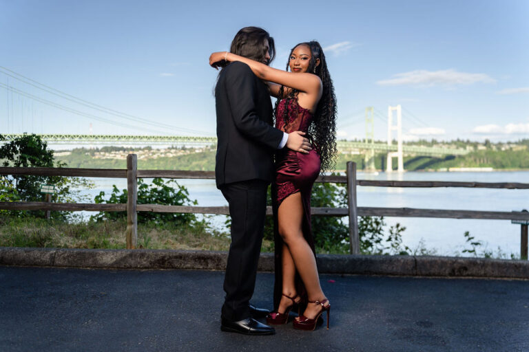 Prom couple embracing and smiling at the Tacoma Narrows Bridge overlook, Gig Harbor and Kitsap prom photography. prom pictures Kitsap County Tacoma Narrows