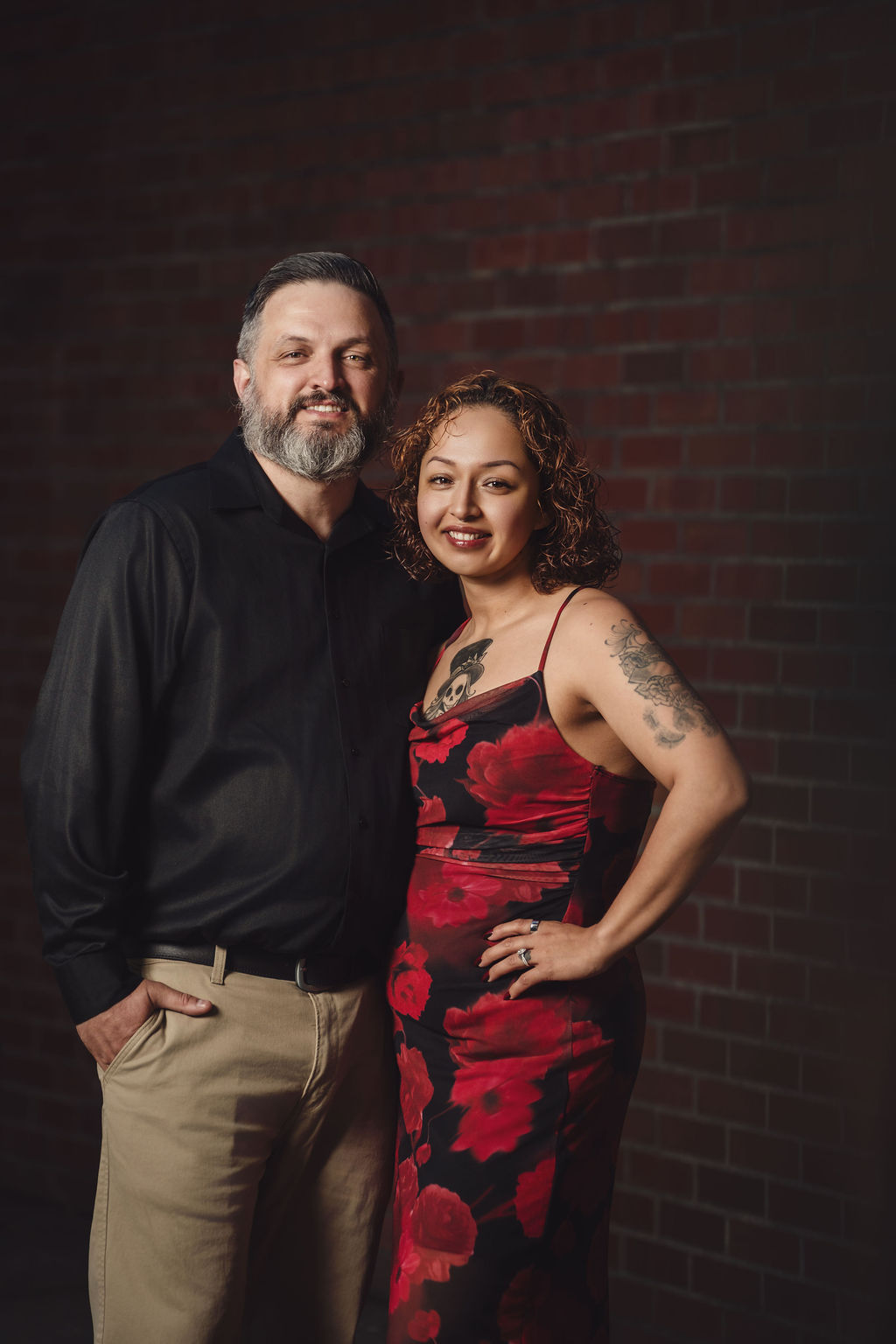 Editorial engagement portrait of a couple against a moody brick wall in Tacoma