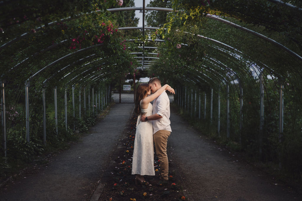 Couple holding hands among rose beds in Tacoma Washington