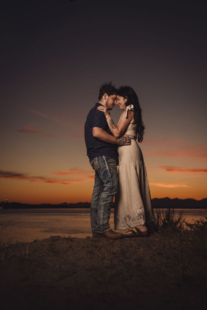 Engaged couple kissing on the beach at sunset at Chambers Bay in University Place