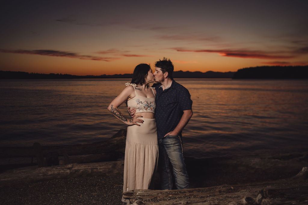 Engaged couple kissing on the beach at golden hour at Chambers Bay near Tacoma