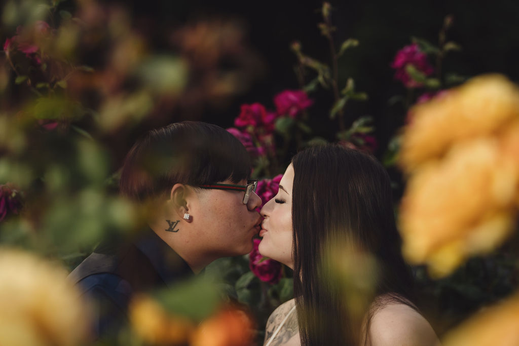 Couple in white dress and black suit among blooming roses at golden hour, Point Defiance Park Tacoma, Nautical Moments Photography