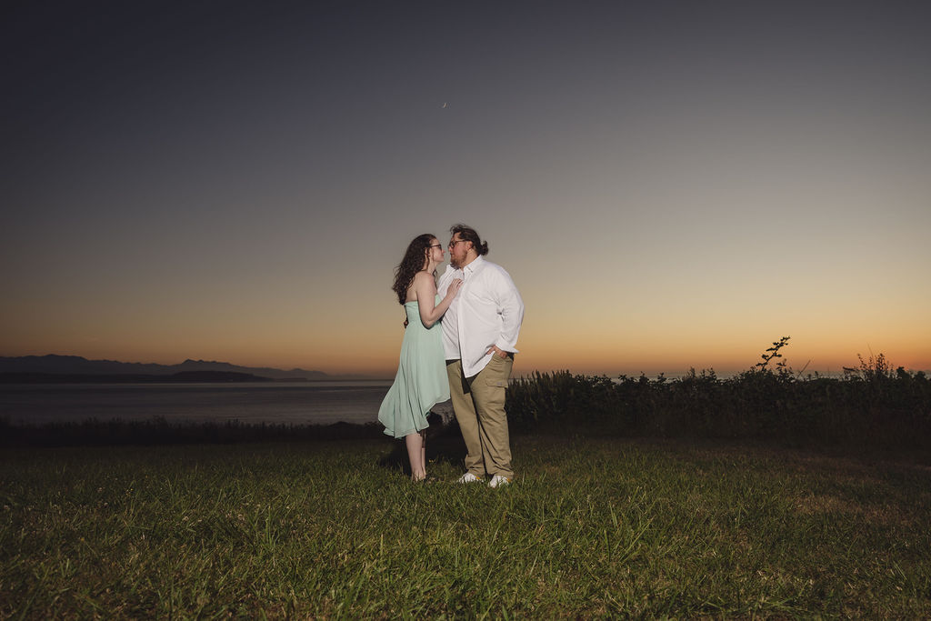 Couple walking hand in hand along the Fort Casey shoreline at sunset