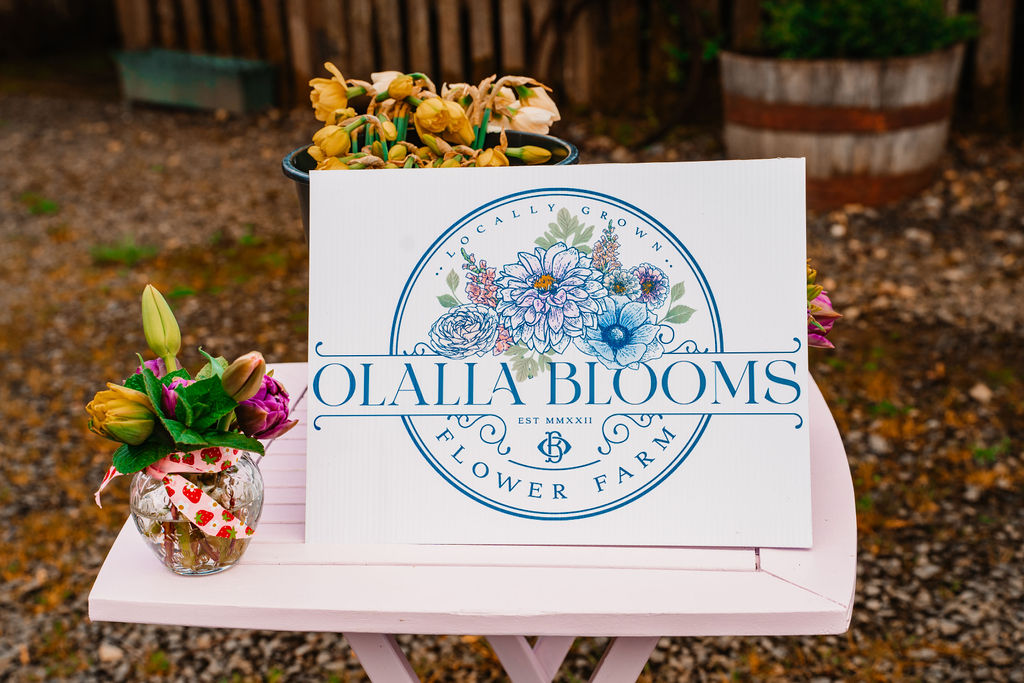 Olalla Blooms branded flower stand with a fresh bouquet in Olalla Washington
