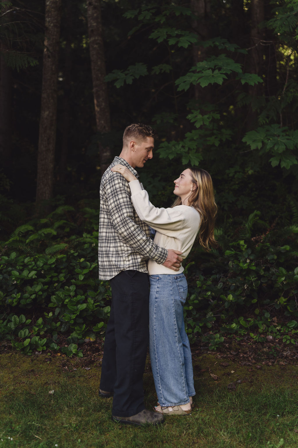 Engagement session couple in soft evening light at the forest edge at Scenic Beach State Park in Seabeck, Washington