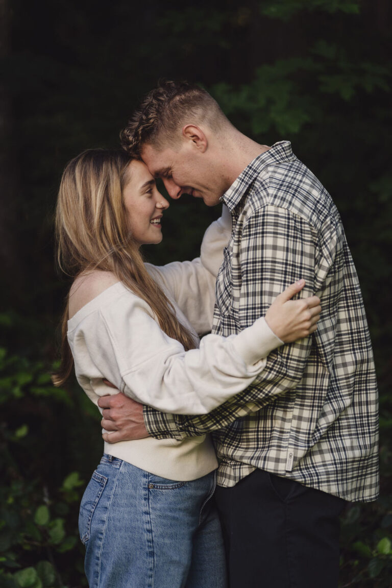 Engaged couple forehead to forehead in soft evening light during a Kitsap County engagement session