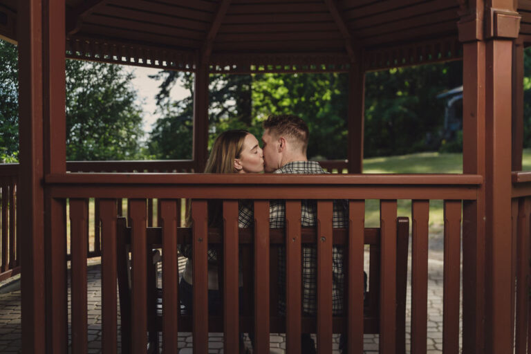 Engaged couple kissing inside the gazebo at Scenic Beach State Park in Seabeck
