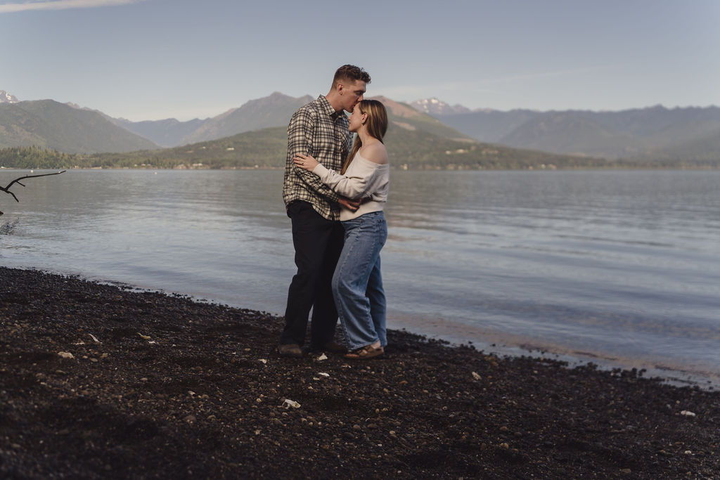 Engaged couple kissing along the Hood Canal waterfront at Scenic Beach State Park
