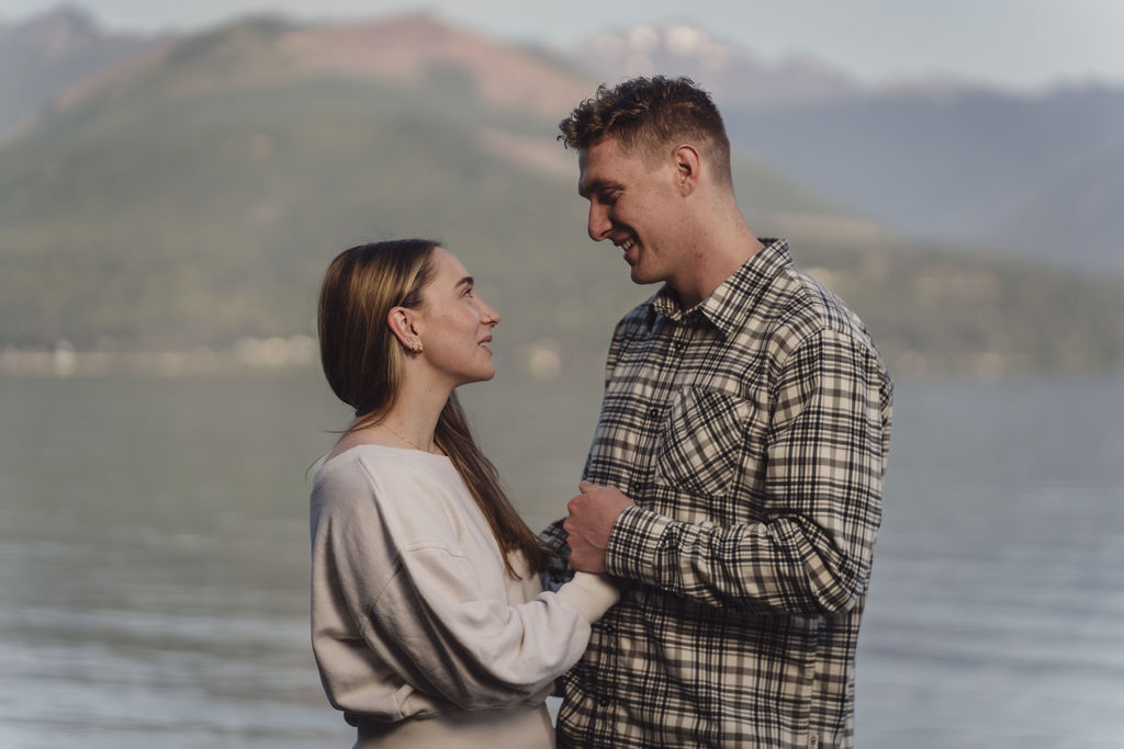 Engagement photos in soft evening light with the Olympic Mountains across Hood Canal at Scenic Beach State Park in Kitsap County