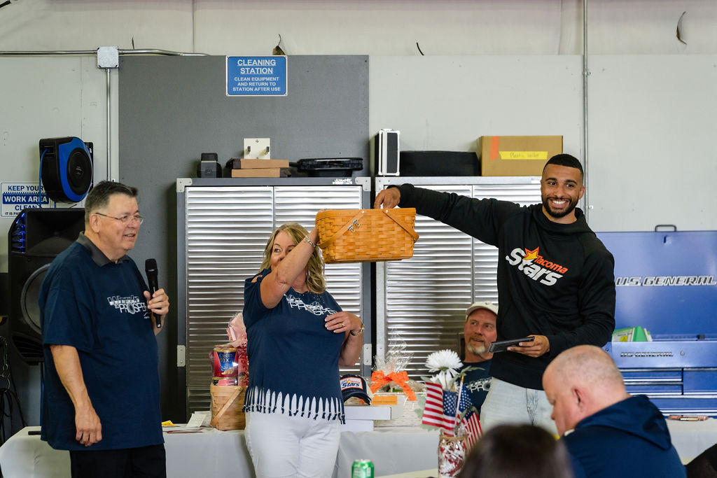 Prize basket held high as a winner covers her face at the Tacoma charity event