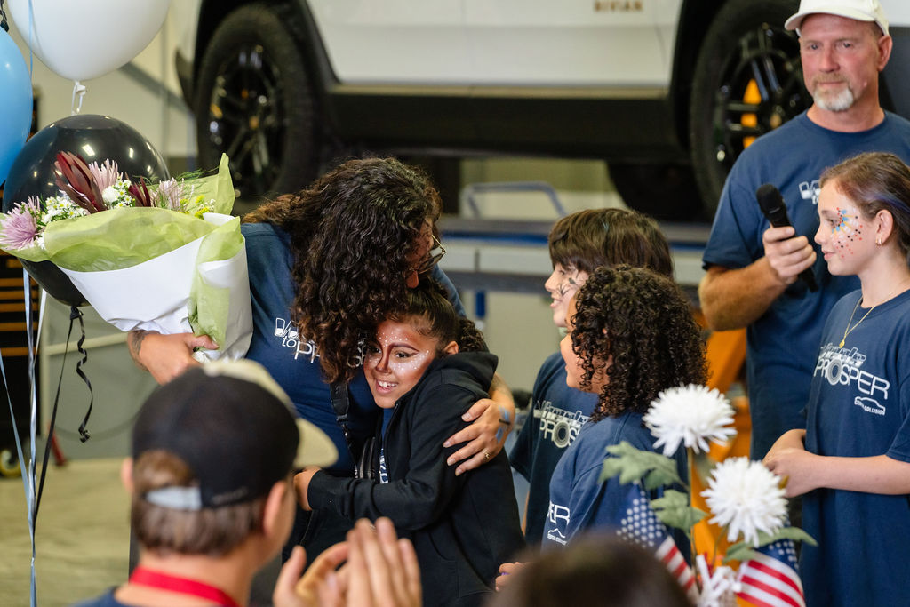 Mother embracing her daughter during an emotional car donation event in Tacoma