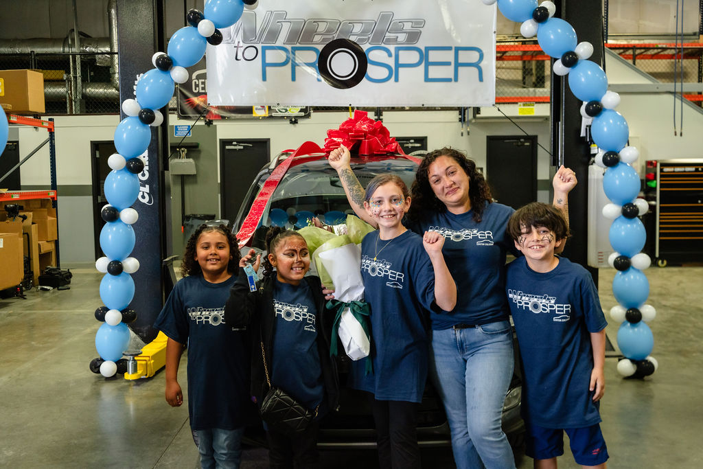 Mother and four daughters cheering in front of a donated car in Tacoma
