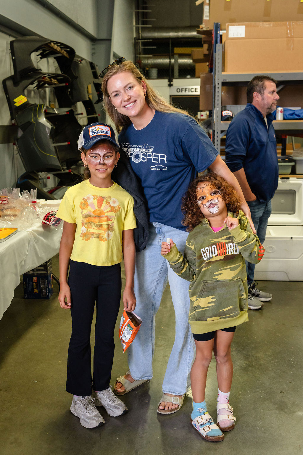 Woman and two girls with painted faces smiling at a Tacoma community charity event